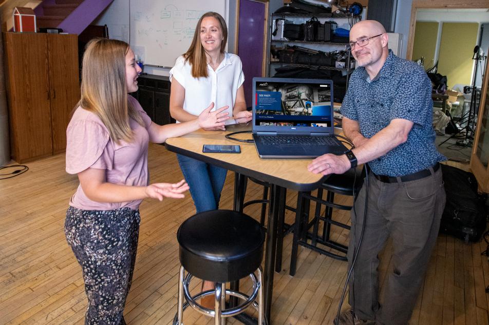 Ashley, Lauren, and Matt discuss a website design on laptop